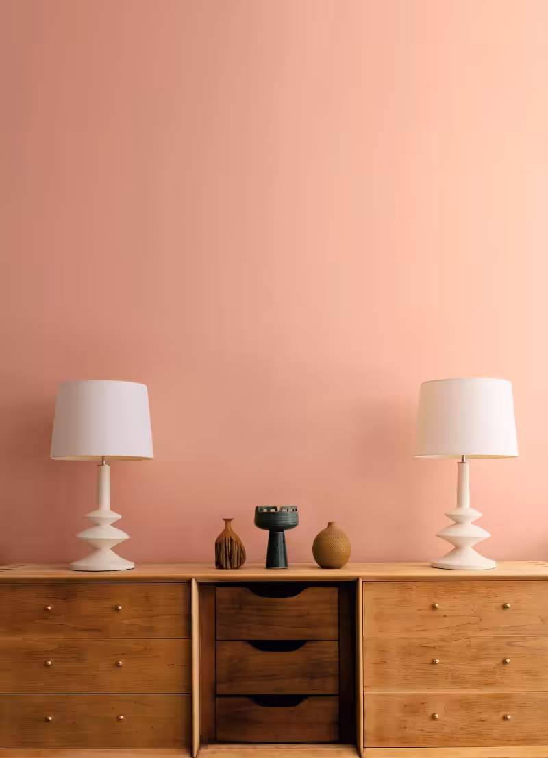 drawer and white desk lamps in front of a wall painted with Benjamin Moore Tofino Sunset colour