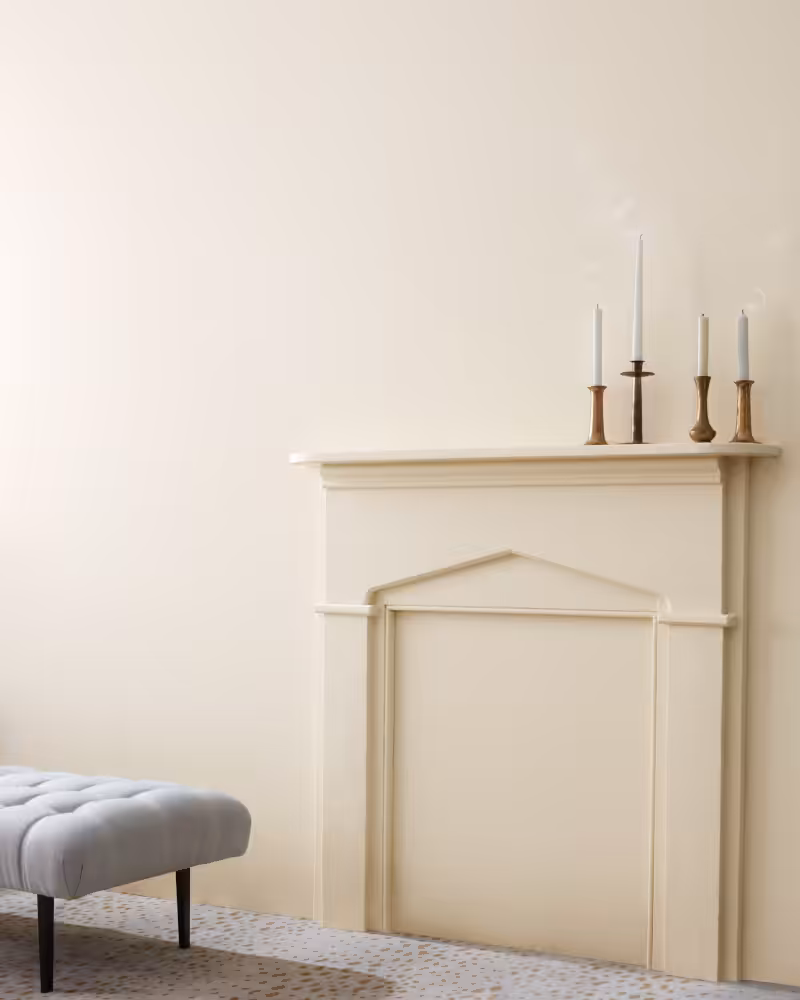 beige fireplace mantel with candles in front of a wall painted with Benjamin Moore Etiquette colour