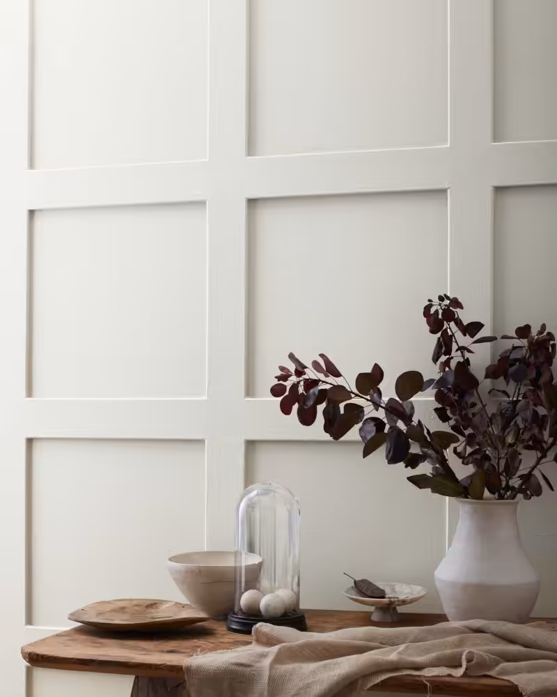 wooden table and vase with flowers in front of a wall painted with Benjamin Moore Gray Owl colour