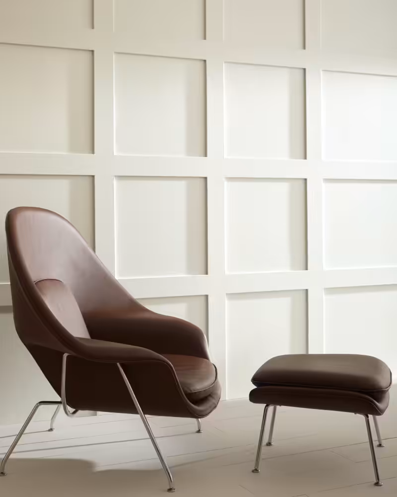 brown leather chair and footrest in front of a wall painted with Benjamin Moore White Heron colour