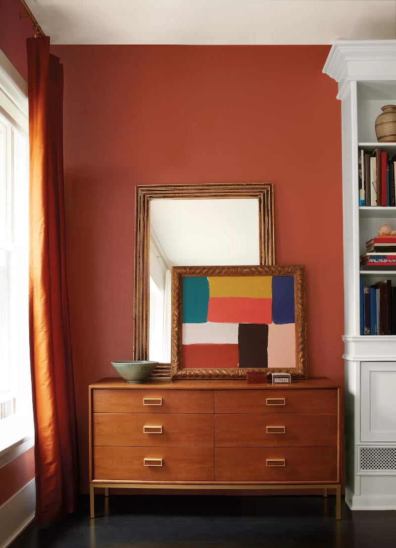 benjamin moore cinnamon painted on wall with wood dresser in front and natural light from window