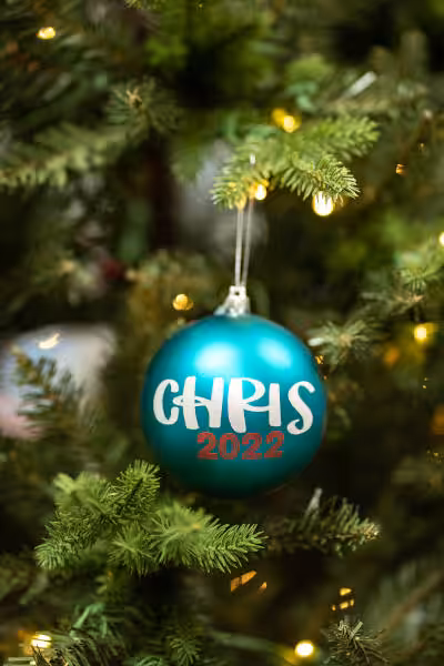 hanging teal coloured custom christmas ball with chris 2022