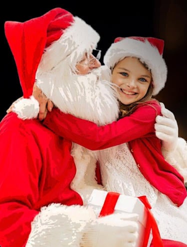 smiling happy girl sitting on santa's knee