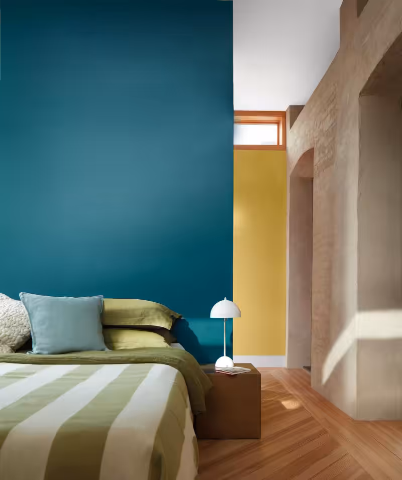 green and white striped bedcover on bed in front of wall painted benjamin moore north sea green colour