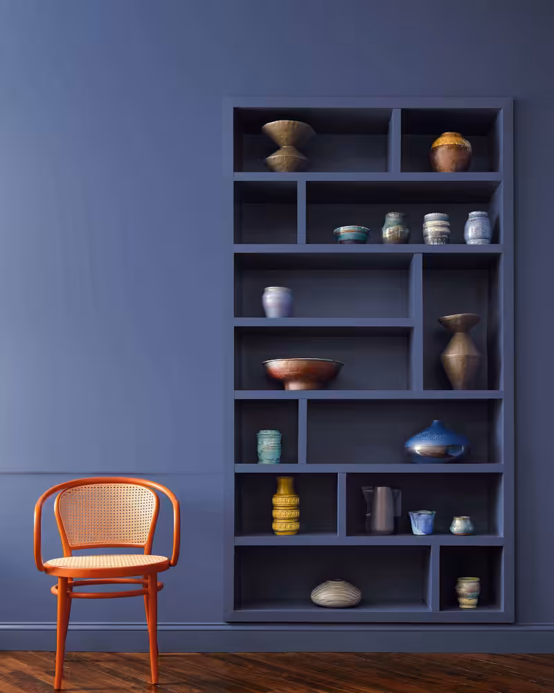book shelf and simple chair in front of wall painted in benjamin moore blue nova colour