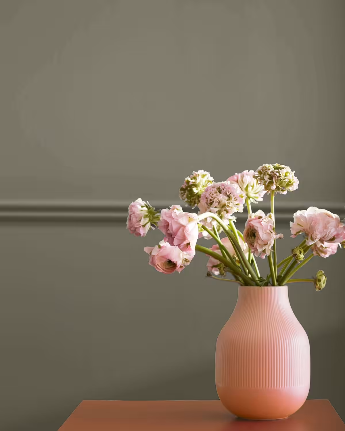 wall painted with benjamin moore antique pewter colour with a vase of roses sitting on a table in front