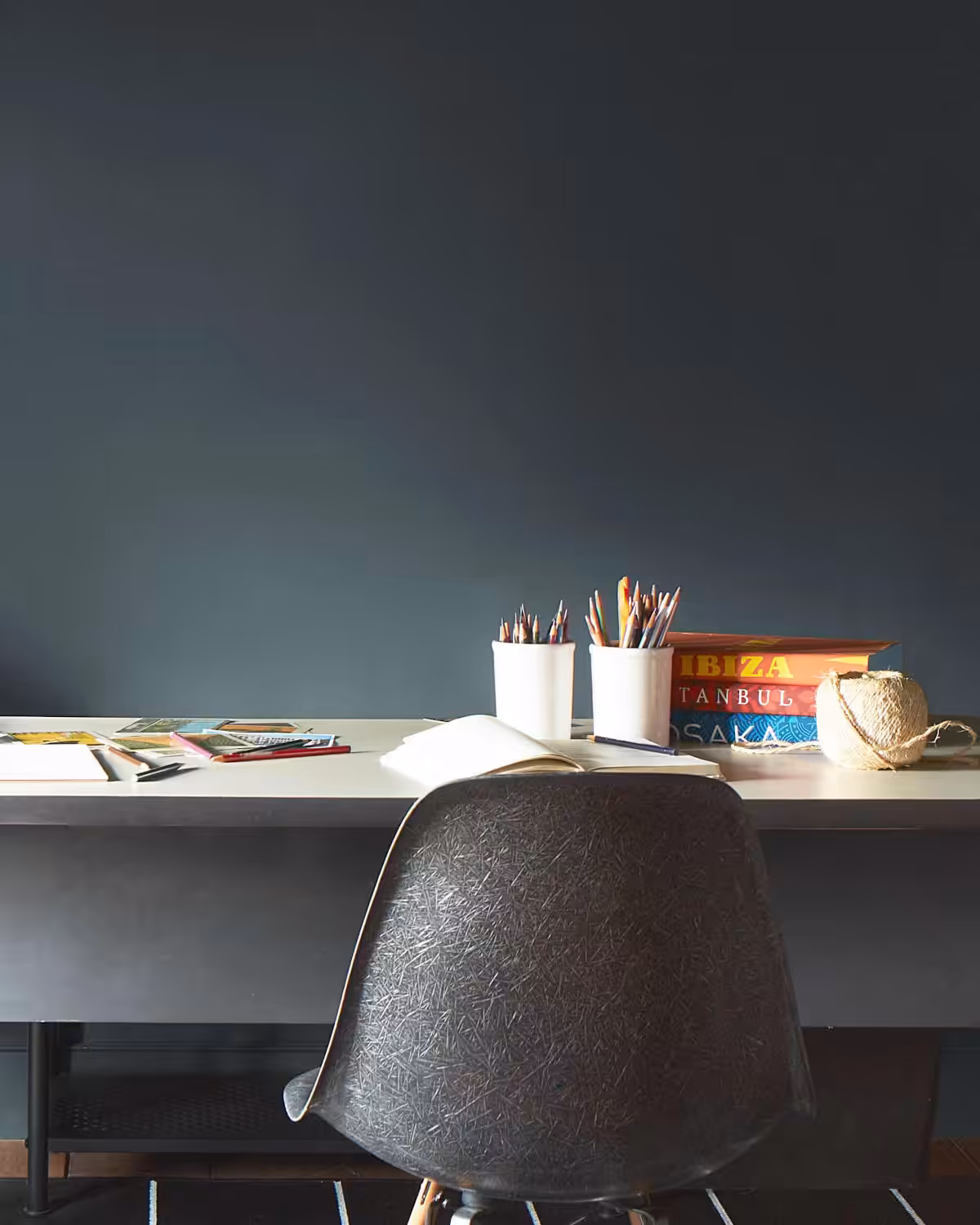 a wall painted in Benjamin Moore's regent green colour behind a desk and chair