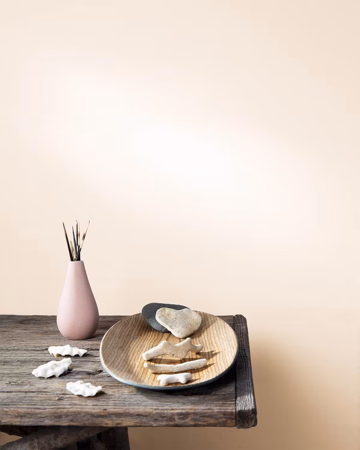 wall painted with benjamin moore's pristine colour and dark wood table with a few items on it.